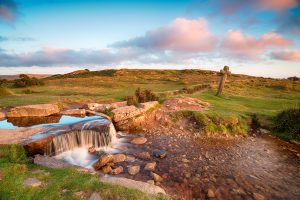 Beautiful evening light at Windy Post and old granite cross also known as the Beckamoor Cross on Dartmoor national park in Devon